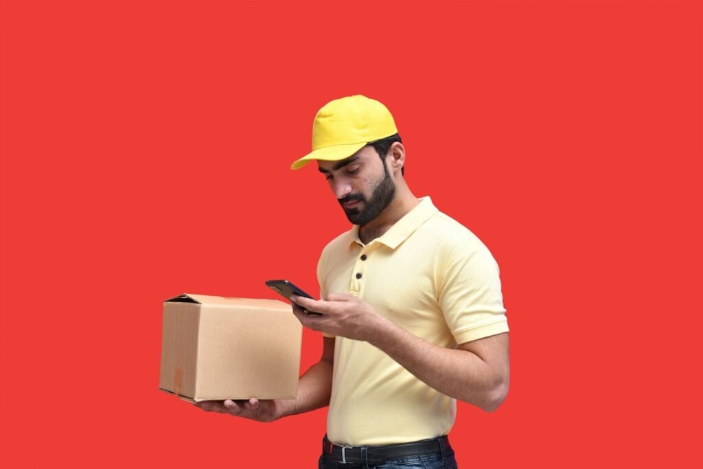 a man in a yellow hard hat looking at a phone